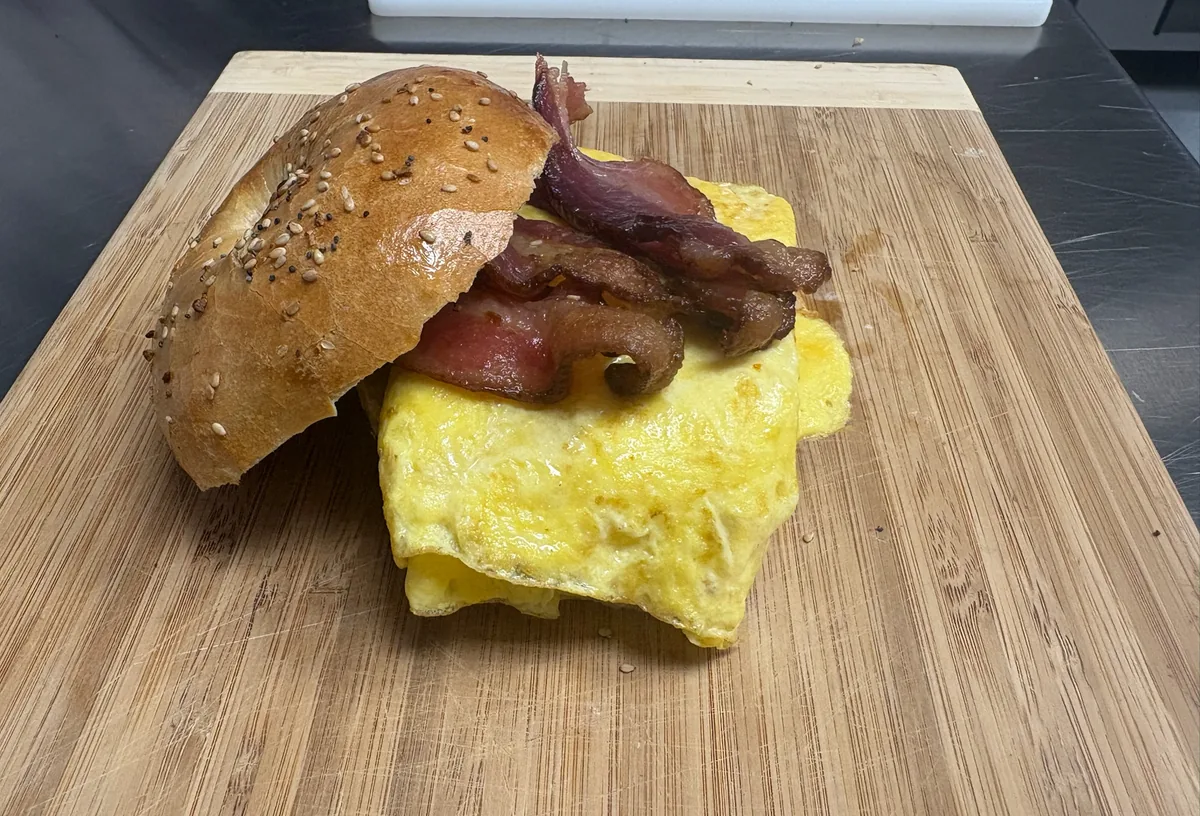 A B's Bagels breakfast sandwich with egg, bacon and cheese on an everything bagel