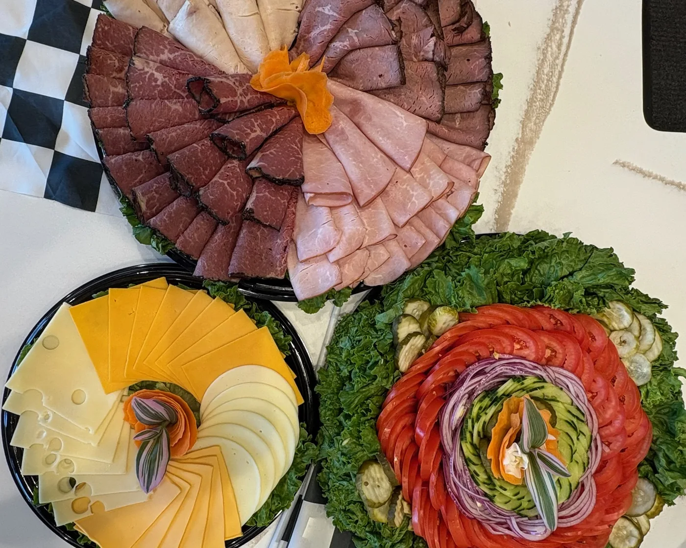 A B's Bagels deli platter of sliced meats beside cheese and relish trays